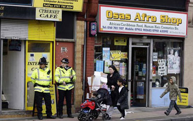 British police officers guard an internet cafe in Manchester, northern England April 9, 2009.