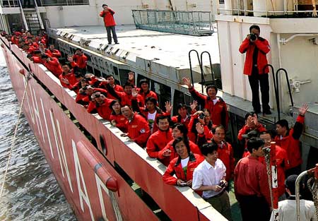 Crew members of the Chinese Antarctic exploration vessel, 'Snow Dragon,' wave to people on land upon their arrival in Shanghai, east China, on April 9, 2009. 