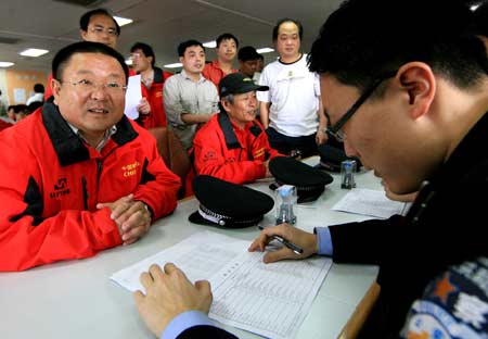 Qin Weijia (1st L), deputy leader of the Chinese Antarctic exploration vessel 'Snow Dragon', waits to go through the entry formality upon his arrival in Shanghai, east China, on April 9, 2009.