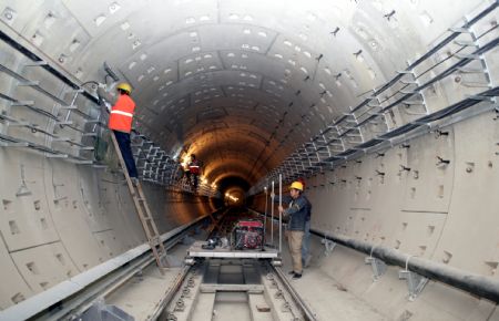 Workers install lamps at the construction site of the tunnel of the No. 4 Subway Line in Beijing, capital of China, April 8, 2009. The construction of the new subway line is well under way. (Xinhua/Li Fangyi)