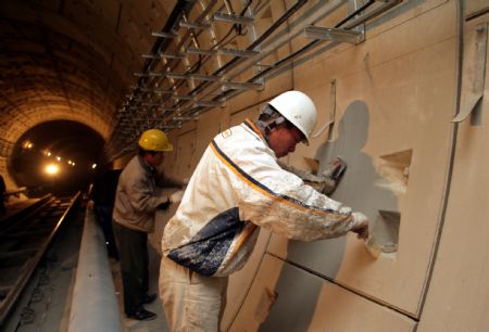 Workers paint the tunnel of the No. 4 Subway Line in Beijing, capital of China, April 8, 2009. The construction of the new subway line is well under way. (Xinhua/Li Fangyi)