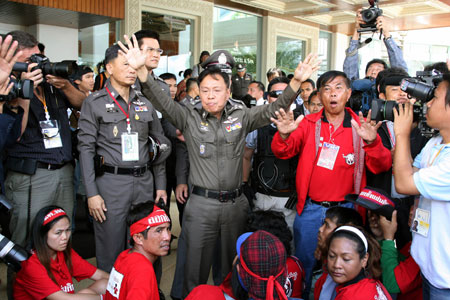 Security officials calm the anti-government 'red-shirted' protestors at the ASEAN related summits venue in Pattaya, Thailand, April 11, 2009. [Zhang Fengguo/Xinhua]