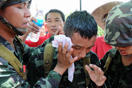 A riot police is hurt as the anti-government 'red shirt' protestors force their way to enter one of the venues of the 14th ASEAN Summit and Related Summits in Pattaya, Thailand, April 11, 2009. [Xinhua] 