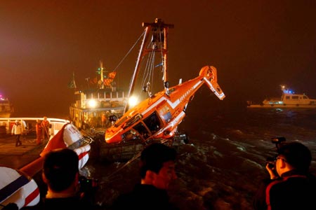 The wreckage of a helicopter from China's Antarctic exploration ship Xuelong is hoisted up almost a nautical mile from its crash site in the East China Sea off Shanghai, April 12, 2009. 