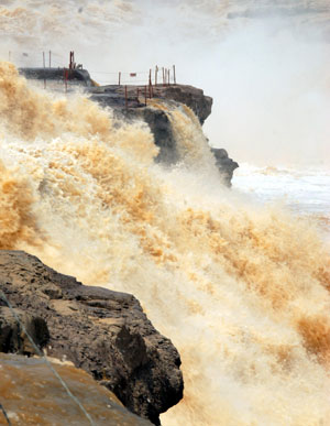 Photo taken on April 12, 2009 shows the spectacular torrential Hukou (Kettle Mouth) Waterfall on the Yellow River, in Yichuan, northwest China's Shaanxi Province. The scenery zone of Hukou Waterfall has been reopened to tourists as of April 1 after a moratorium on account of unprecedented ice floes jam on the Yellow River in early January.[Rao Erbao/Xinhua]