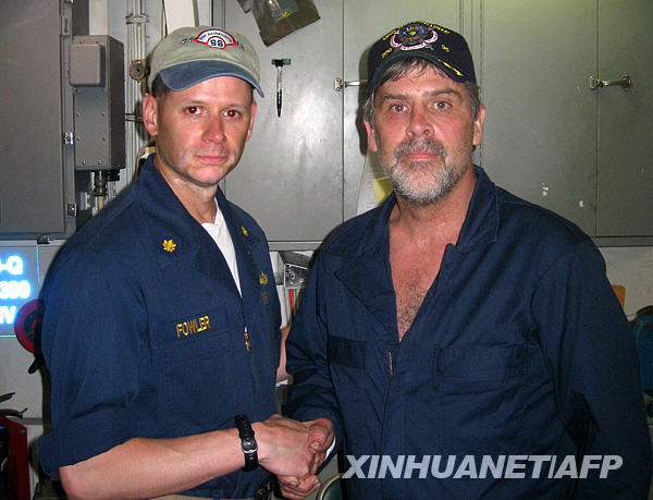  In this photo released by the U.S. Navy, Maersk-Alabama Capt. Richard Phillips, right, shakes hands with an executive officer of USS Bainbridge after being rescued by U.S Naval Forces off the coast of Somalia on Sunday April 12, 2009. [Xinhua/AP]