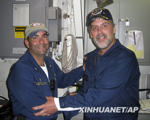 In this photo released by the U.S. Navy, Maersk-Alabama Capt. Richard Phillips, right, shakes hands with Lt. Cmdr. David Fowler, executive officer of USS Bainbridge after being rescued by U.S Naval Forces off the coast of Somalia on Sunday April 12, 2009. [Xinhua/AP] 