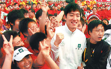 Hurdler Liu Xiang is surrounded by fans at the opening ceremony of the Beijing International Long-distance Running Festival at Tian'anmen Square on April 12, 2009.[China Daily]