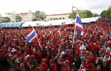 Supporters of former Thai Prime Minister Thaksin Shinawatra stand on the road outside Government House during an anti-government protest in Bangkok April 13, 2009. The Thai army cracked down on anti-government protesters on Monday, firing warning shots at a major junction in the capital at demonstrators who responded by hurling petrol bombs, witnesses said. [Xinhua/Reuters]