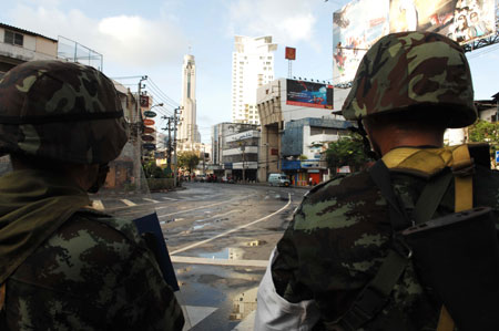 Thai army soldiers guard at the Din Daeng intersection in Bangkok, capital of Thailand, on April 13, 2009. At least 77 were wounded when hundreds of army soldiers and anti-government protesters clashed in Bangkok early Monday morning, Thai media reports. [Xinhua]