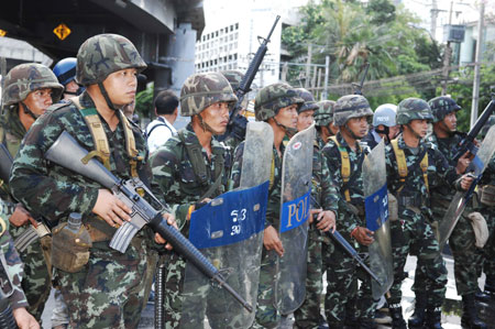 Thai army soldiers guard at the Din Daeng intersection in Bangkok, capital of Thailand, on April 13, 2009. At least 77 were wounded when hundreds of army soldiers and anti-government protesters clashed in Bangkok early Monday morning, Thai media reports. [Thana Nuntavoranut/Xinhua]