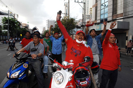 Anti-government protesters shout slogans at the Din Daeng intersection in Bangkok, capital of Thailand, on April 13, 2009. At least 77 were wounded when hundreds of army soldiers and anti-government protesters clashed in Bangkok early Monday morning, Thai media reports. [Thana Nuntavoranut/Xinhua]