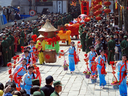 Chinese performers present a celebration of good harvest during a street parade in front of a gathering of locals and tourists at a temple fair in Wuxi city, east China&apos;s Jiangsu Province, April 11, 2009. A variety of performances listed as local cultural heritages were showcased at the temple fair as a promotion of local tourism. [Photo: Xinhua] 