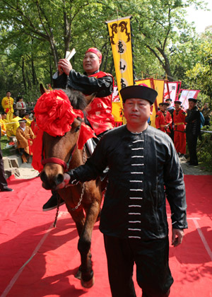 Chinese performers present a celebration of old fashions during a street parade in front of a gathering of locals and tourists at a temple fair in Wuxi city, east China's Jiangsu Province, April 11, 2009. [Photo: Xinhua] 