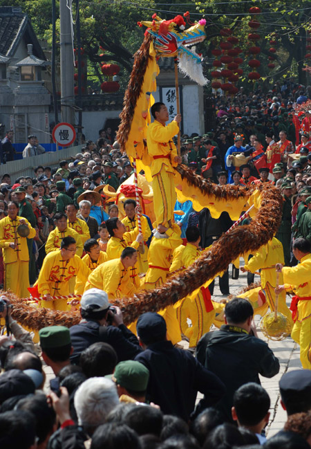 Chinese performers present a celebration of good harvest during a street parade in front of a gathering of locals and tourists at a temple fair in Wuxi city, east China&apos;s Jiangsu Province, April 11, 2009. [Photo: Xinhua] 