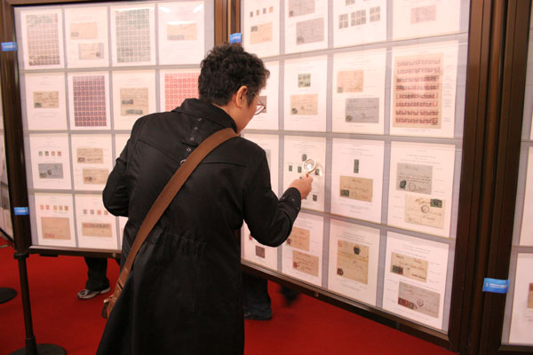  A visitor to the China 2009 World Stamp Exhibition watches the stamps on display in the new hall of Luoyang Museum, in Luoyang, central China's Henan province on April 10, 2009. [Photo: CRIENGLISH.com/Zhu Jin] 