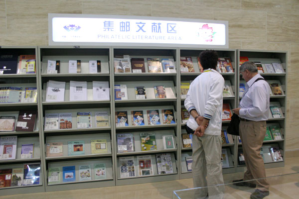 Visitors to the China 2009 World Stamp Exhibition watch the Philatelic Literature Area in the new hall of Luoyang Museum, in Luoyang, central China&apos;s Henan province on April 10, 2009. [Photo: CRIENGLISH.com/Zhu Jin] 