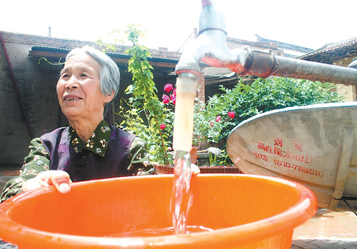 The file photo shows Ran Yulian, a villager in Linxia County, northwest China's Gansu Province, is happy to see fresh, safe tap water has been accessible to her home. The Ministry of Environmental Protection initiated a special fund to fight rural environment problems, such as pollution of drinking water sources, in November, 2009.