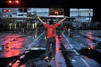 A Thai supporter of exiled Prime Minister Thaksin Shinawatra faces the Thai army at Ding Daeng intersection in the early morning, in Bangkok. Thousands of Thai anti-government protesters clashed with armed soldiers and Bangkok residents Monday, leaving two dead and 113 injured in street battles that raged across the capital.[Nicolas Asfouri/CCTV/AFP] 