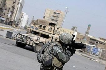 A US soldier aims his gun during an operation against anti-Qaeda militiamen in Baghdad's Fadel district. President Barack Obama said he would not speed up troop withdrawals from Iraq, arguing the country was 'moving in the right direction' but still needed US help. [Ahmad al-Rubaye/AFP] 