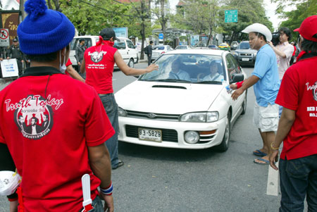 Anti-government protestors demand to examine a var during a rally at the Government House in Bangkok, capital of Thailand, April 13, 2009. Anti-government protestors have set up several blocks to control the people who wanted to enter the site of the rally. 