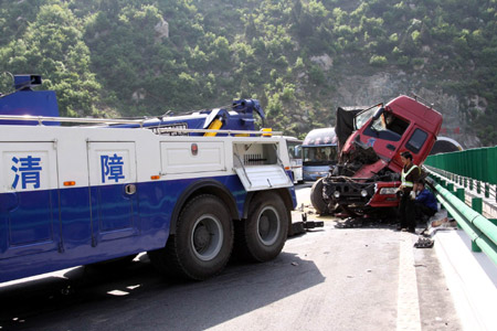 A wrecker clears the accident spot on the Xishang Expressway in northwest China's Shaanxi Province, April 14, 2009. [Wu Anbiao/Xinhua] 