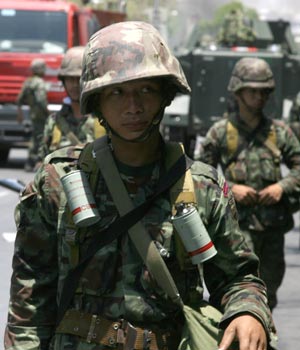 Thai army soldiers block the road outside the Government House in Bangkok, capital of Thailand, April 14, 2009. Thai anti-government protesters began to head home Tuesday afternoon after their leaders surrendered to police and called an end to the rally. But the security in the capital Bangkok is still tight. [Zhang Fengguo/Xinhua]