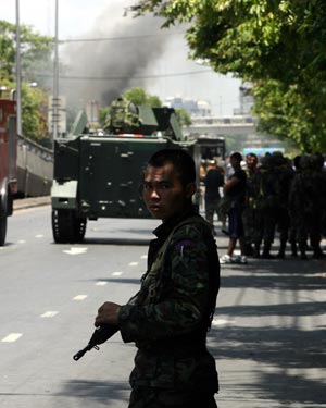 Thai army soldiers block the road outside the Government House in Bangkok, capital of Thailand, April 14, 2009. Thai anti-government protesters began to head home Tuesday afternoon after their leaders surrendered to police and called an end to the rally. But the security in the capital Bangkok is still tight. [Zhang Fengguo/Xinhua]