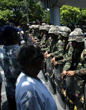 Thai army soldiers block the road outside the Government House in Bangkok, capital of Thailand, April 14, 2009. Thai anti-government protesters began to head home Tuesday afternoon after their leaders surrendered to police and called an end to the rally. But the security in the capital Bangkok is still tight. [Zhang Fengguo/Xinhua]