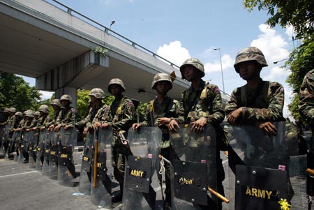 Thai army soldiers block the road outside the Government House in Bangkok, capital of Thailand, April 14, 2009. Thai anti-government protesters began to head home Tuesday afternoon after their leaders surrendered to police and called an end to the rally. But the security in the capital Bangkok is still tight. [Zhang Fengguo/Xinhua]