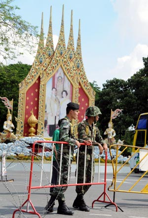 Thai soldiers stand guard near the royal Chiralada Palace in Bangkok, capital of Thailand, April 14, 2009. Thai anti-government protesters began to head home Tuesday afternoon after their leaders surrendered to police and called an end to the rally. But the security in the capital Bangkok is still tight. [Huang Haimin/Xinhua]