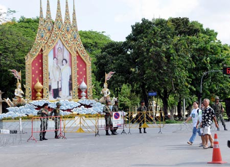 Thai soldiers guard as tourists pass by near the royal Chiralada Palace in Bangkok, capital of Thailand, April 14, 2009. Thai anti-government protesters began to head home Tuesday afternoon after their leaders surrendered to police and called an end to the rally. But the security in the capital Bangkok is still tight. [Huang Haimin/Xinhua]