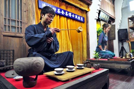 Contestants go through the prescribed procedures for the first Folk Tea Doctorate Dan Level Contest of Tai Chi Tea Ceremony, at Hangzhou, east China's Zhejiang Province, April 13, 2009. 