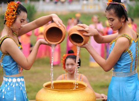 Girls pour water brought from the Lancang River into a jar in a ceremony held in Jinghong, Dai Autonomous Prefecture of Xishuangbanna, southwest China's Yunnan Province April 15, 2009. People celebrate the annual and traditional Water Splashing Festival, which signifies the visit of spring.[Xinhua]