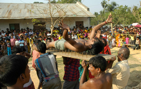 A Hindu devotee lies on a bed of nails during the annual 'Shiva Gajan' religious festival in Pratapgarh, about 30 km (19 miles) from Agartala, capital of India's northeastern state of Tripura, April 14, 2009. [Xinhua/Reuters]