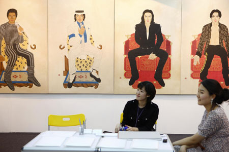 Visitors look at paintings in the opening day of the China International Gallery Exposition (CIGE) 2009 in Beijing April 15, 2009. The fair showcases over 80 selected galleries and presents some 5,000 pieces of art projects including painting, sculptures, multimedia creations.[Li Mingfang/Xinhua]