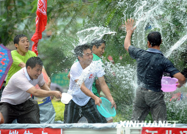 Citizens splash water on each other in the street.[Xinhua]