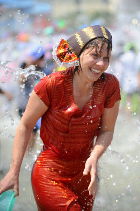 A foreign tourist reacts during a splash water celebration in Jinghong, Dai Autonomous Prefecture of Xishuangbanna, southwest China's Yunnan Province April 15, 2009. People celebrate the annual and traditional Water Splashing Festival, which signifies the visit of spring.[Qin Qing/Xinhua]