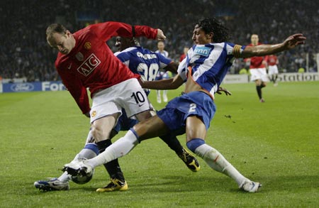 Manchester United's Wayne Rooney (L) is challenged by Porto's Bruno Alves during their Champions League quarter-final, second leg soccer match at Dragon stadium in Porto, April 15 2009. 