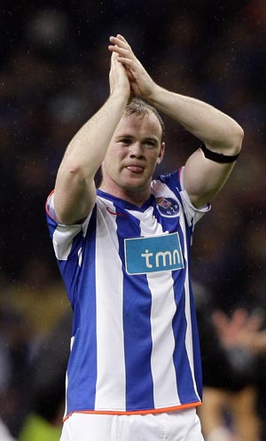 Manchester United's Wayne Rooney wears a Porto jersey as he celebrates winning their match against Porto in their Champions League quarter-final, second leg soccer match at Dragon stadium in Porto, April 15 2009.