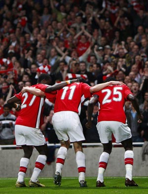 Arsenal's Emmanuel Adebayor (R) celebrates with teammates Robin Van Persie (C) and Emmanuel Eboue after scoring against Villarreal during their Champions League quarter-final, second leg soccer match at the Emirates stadium in London April 15, 2009.
