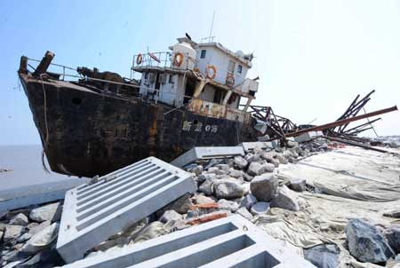 Photo taken on April 16, 2009 shows a dredger lies on the beach after being badly damaged during a gale off north China's Tianjin Municipality. Three crew members were confirmed dead and six others were missing after two dredgers were badly damaged on April 16.[Xinhua]