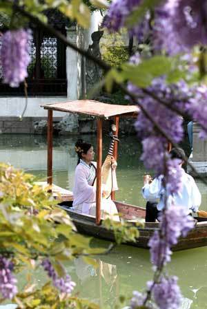  An actress performs Suzhou Pingtan on a boat in the Lingering Garden in Suzhou City, east China's Jiangsu Province, April 15, 2009. [Xinhua]