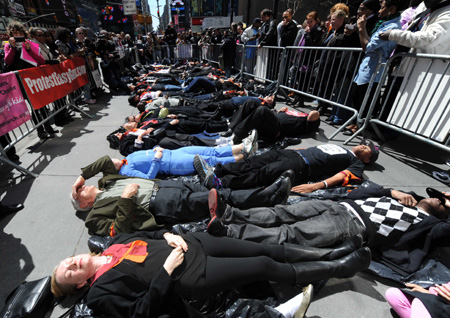 Demonstrators with the group New Yorkers Against Gun Violence and activists from Binghamton N.Y. lie down on the sidewalk observing three minutes' silence, at Times Square in New York, the United States, April 16, 2009. Demonstrators chose to hold the event on the the second anniversary of the Virginia Tech shootings on Thursday to try to get support for sensible guns laws.[Xinhua]