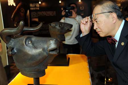 Visitors attend an exhibition of animal heads sculptures constructed with ancient technique to mimic the sculptures of the Yuanmingyuan Imperial Summer Palace in Guangzhou, capital of south China's Guangdong Province, April 16, 2009. [Liu Dawei/Xinhua]