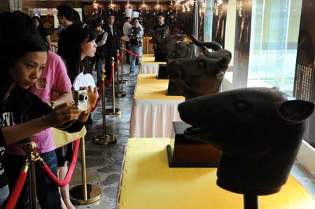 Visitors attend an exhibition of animal heads sculptures constructed with ancient technique to mimic the sculptures of the Yuanmingyuan Imperial Summer Palace in Guangzhou, capital of south China's Guangdong Province, April 16, 2009. [Xinhua]