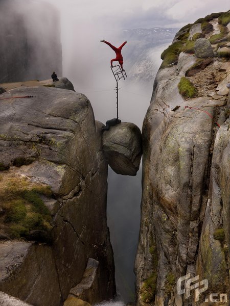 Eskil Ronningsbakken balancing on a chair above the famous Kjaerag Bolten rock, which isabout 800 meters high, in Norway.