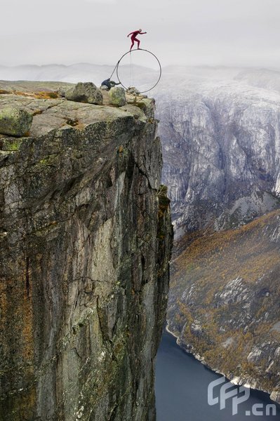 Eskil Ronningsbakken balancing on the side of a 1000 meter high cliff on a steel ring in Kjaerag, Stavanger. [Barcroftmedia/CFP]