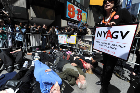 Demonstrators with the group New Yorkers Against Gun Violence and activists from Binghamton N.Y. lie down on the sidewalk observing three minutes' silence for shooting victims in American history, at Times Square in New York, the United States, April 16, 2009. Demonstrators chose to hold the event on the the second anniversary of the Virginia Tech shootings on Thursday to try to get support for sensible guns laws. [Shen Hong/Xinhua] 