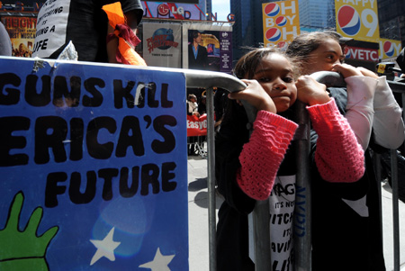 Two girls attend the anti-gun demonstration in Times Square in New York, the United States, April 16, 2009. Demonstrators chose to hold the event on the the second anniversary of the Virginia Tech shootings on Thursday to try to get support for sensible guns laws. [Shen Hong/Xinhua]